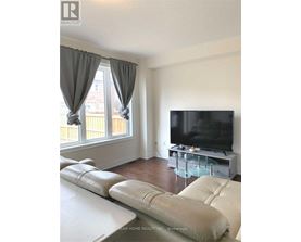 A living room with a white couch and a flat screen TV.
