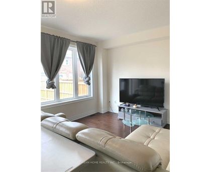 A living room with a white couch and a flat screen TV.