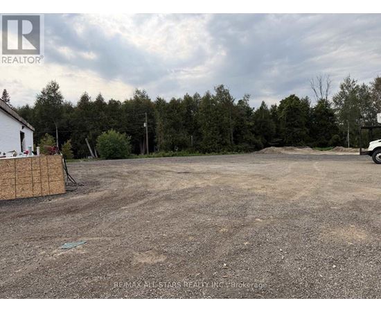 A REALTOR® logo is on a sign in front of a dirt lot.