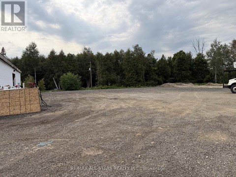 A REALTOR® logo is on a sign in front of a dirt lot.