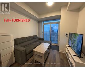 A living room with a grey couch and a flat screen TV.