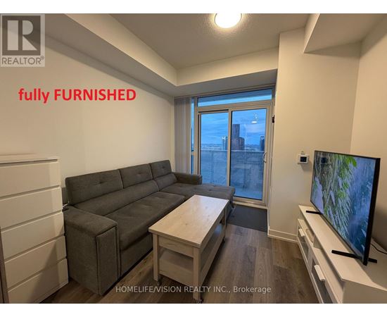A living room with a grey couch and a flat screen TV.