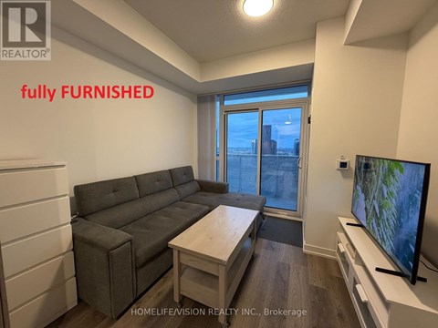 A living room with a grey couch and a flat screen TV.