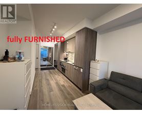 A fully furnished kitchen and living room with a couch and a coffee table.