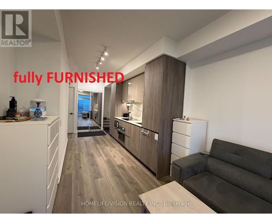 A fully furnished kitchen and living room with a couch and a coffee table.