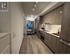 A modern kitchen with wooden cabinets and a marble countertop.