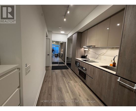 A modern kitchen with wooden cabinets and a marble countertop.