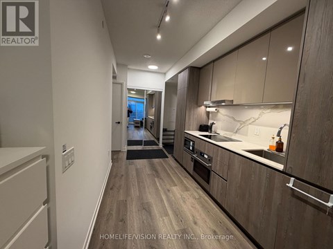A modern kitchen with wooden cabinets and a marble countertop.