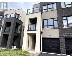 A modern apartment building with balconies and garage doors.