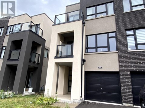 A modern apartment building with balconies and garage doors.