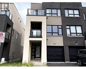A modern apartment building with a car parked in front.