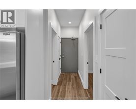 A hallway with a wooden floor and white walls.