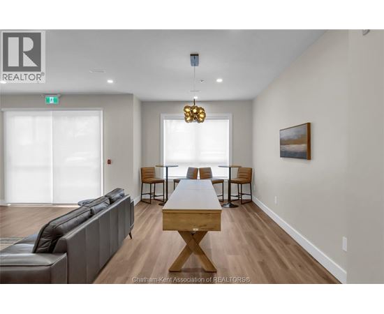 A living room with a grey couch, a wooden table, and a painting on the wall.