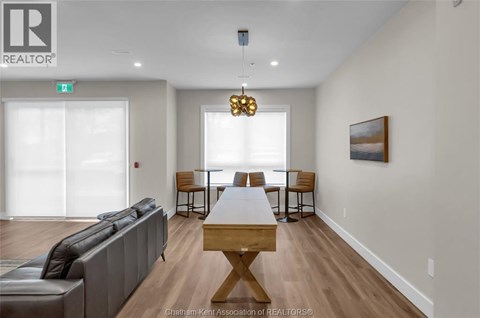 A living room with a grey couch, a wooden table, and a painting on the wall.