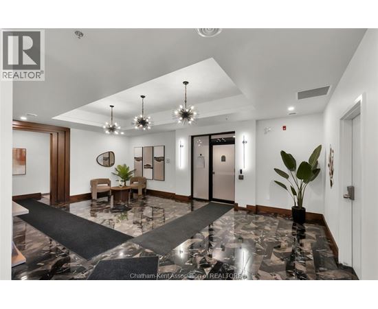 A spacious lobby with a marble floor and a large chandelier.