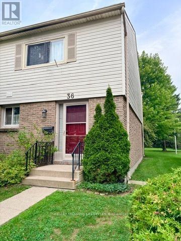 A house with the number 36 on it has a red door and a small front yard.