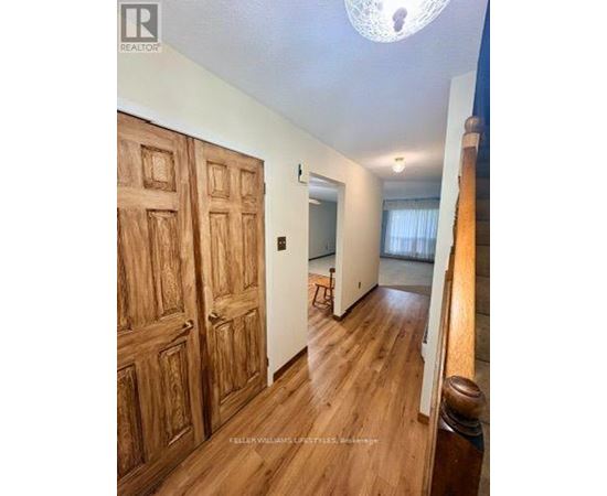 A room with wooden floors and a large wooden door.