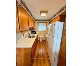 A kitchen with wooden cabinets and a white fridge.