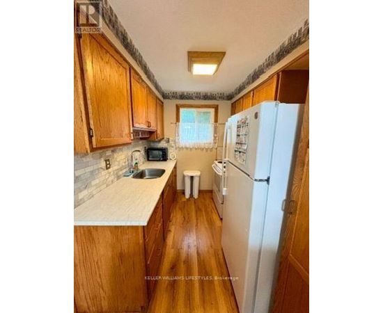 A kitchen with wooden cabinets and a white fridge.