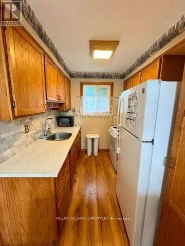A kitchen with wooden cabinets and a white fridge.