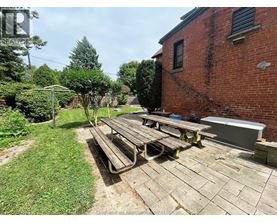 A backyard with a picnic table and a brick building.