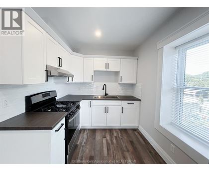 A kitchen with white cabinets and a black stove top oven.