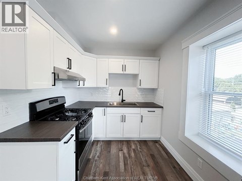 A kitchen with white cabinets and a black stove top oven.