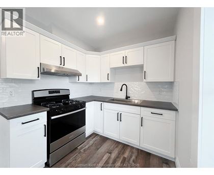 A kitchen with white cabinets and a black stove top.