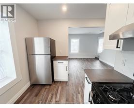 A kitchen with a stainless steel refrigerator and a stove top oven.