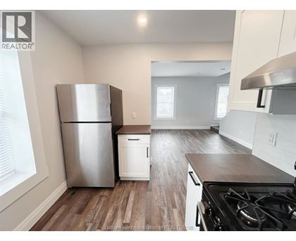 A kitchen with a stainless steel refrigerator and a stove top oven.