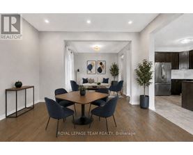 A modern dining room with a round table and chairs.