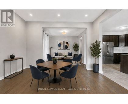 A modern dining room with a round table and chairs.