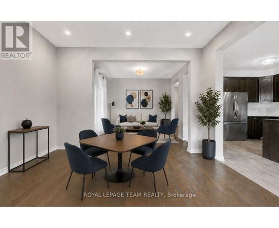 A modern dining room with a round table and chairs.