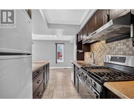 A kitchen with a stove top oven and a refrigerator.