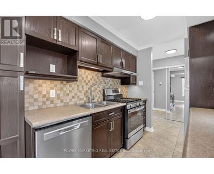 A kitchen with brown cabinets and a tile backsplash.