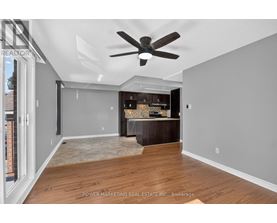 A spacious room with a ceiling fan and a wooden floor.