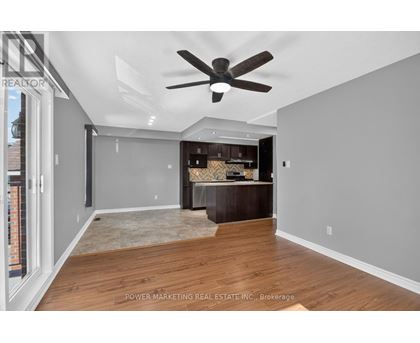 A spacious room with a ceiling fan and a wooden floor.