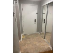 A bathroom with a tiled floor and a white door.