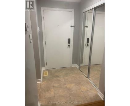 A bathroom with a tiled floor and a white door.