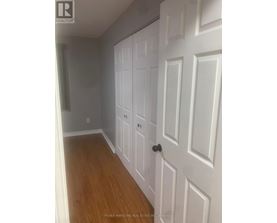 A white door with a black handle is in a room with wooden floors.