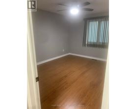 A room with wooden flooring and a ceiling fan.