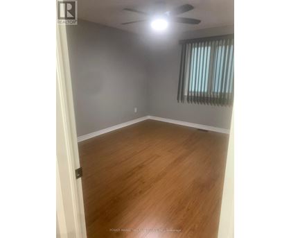 A room with wooden flooring and a ceiling fan.