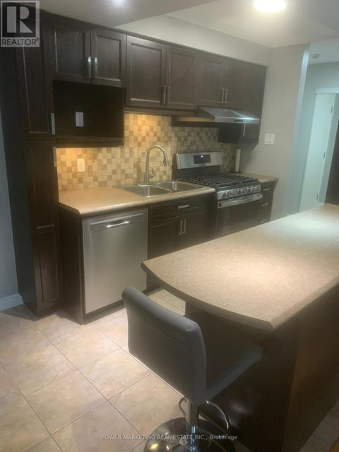 A kitchen with dark brown cabinets and a tile backsplash.