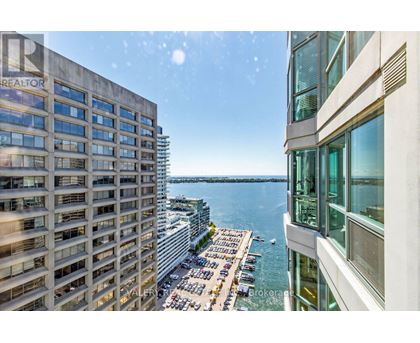 A view from a high-rise building looking down at a parking lot and a body of water.