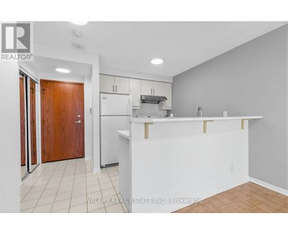 A kitchen with white cabinets and a white counter.