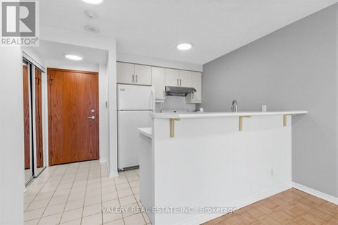 A kitchen with white cabinets and a white counter.