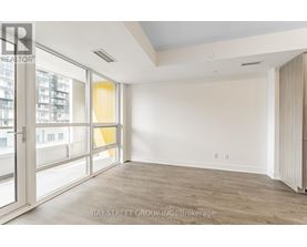 A spacious room with a view of the city through large windows.