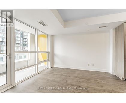 A spacious room with a view of the city through large windows.