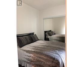 A bedroom with a bed and a mirror on the wall.