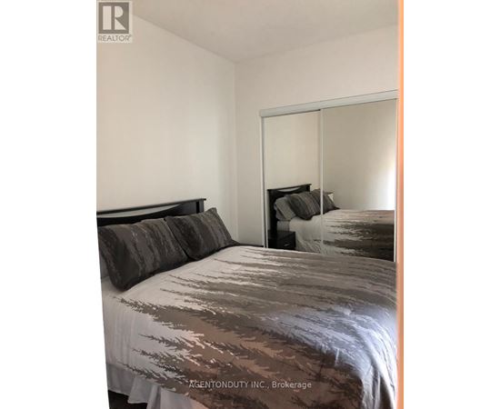 A bedroom with a bed and a mirror on the wall.